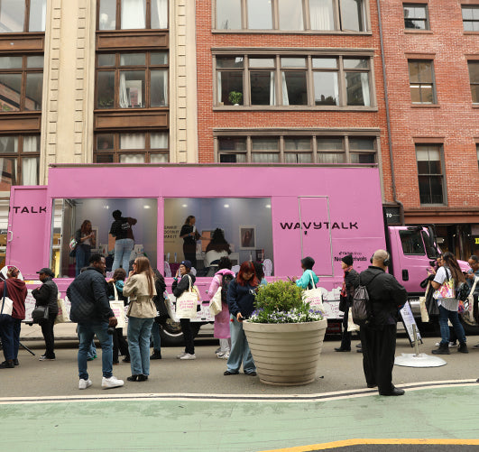 Pink Wavytalk truck with people gathered around in an urban setting