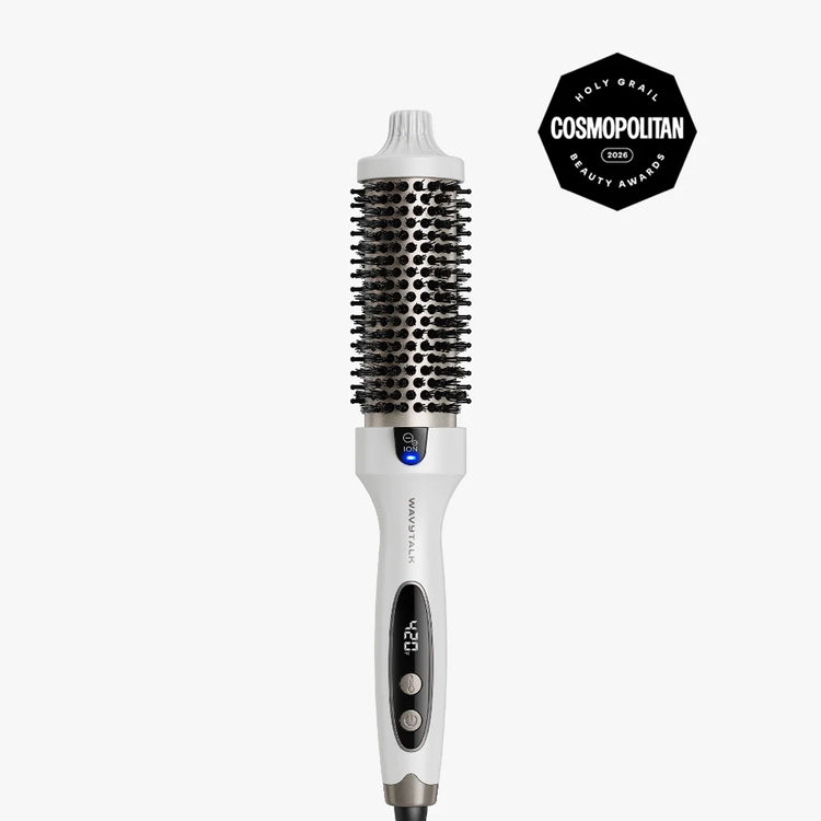 A white and black round hairbrush styling tool with a digital temperature display, shown vertically on a light gray background with a black Cosmopolitan Beauty Award badge in the top right corner.