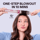 Woman using gray Heatwave Pro hair styling tool with text 'One-Step Blowout in 10 Mins' on a light blue background
