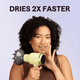 Green Blown Away hair dryer held by a woman, featuring the text "Dries 2X Faster" against a light purple background.