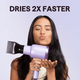 Woman using a purple Blown Away with text 'Dries 2X Faster' on a light purple background