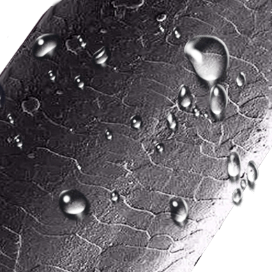 Close-up of a textured black surface with water droplets