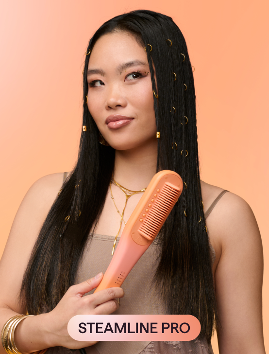 Woman holding a pink 'Steamline Pro' hairbrush against an orange background