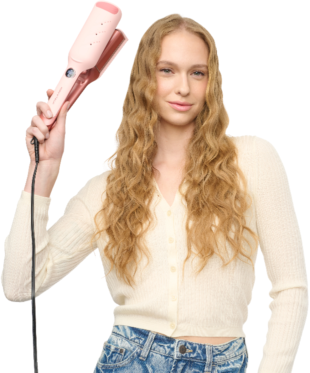Woman with long blonde hair holding a pink hair straightener on a white background