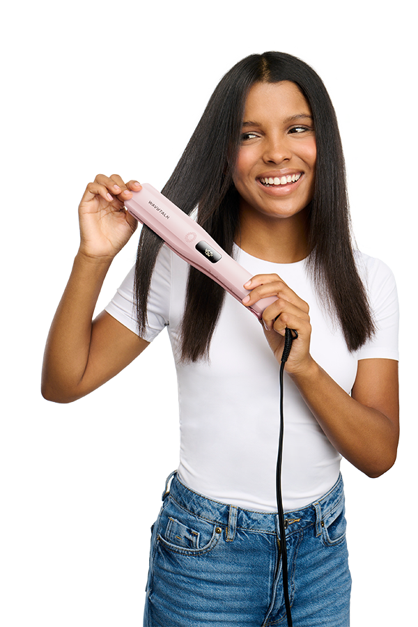 Woman holding a pink hair straightener against a white background