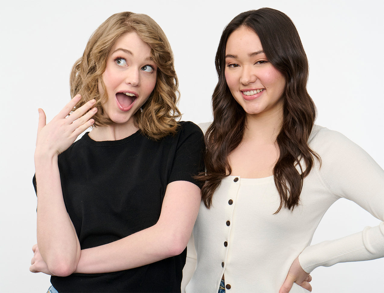 Two women posing for a photo against a white background