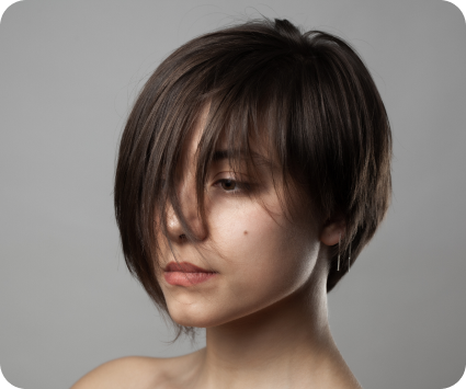 Woman with short brown hair against a gray background