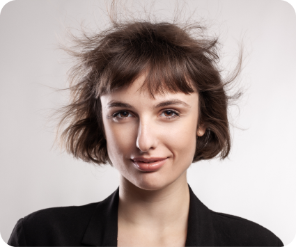 Woman holding a hairbrush against a plain background